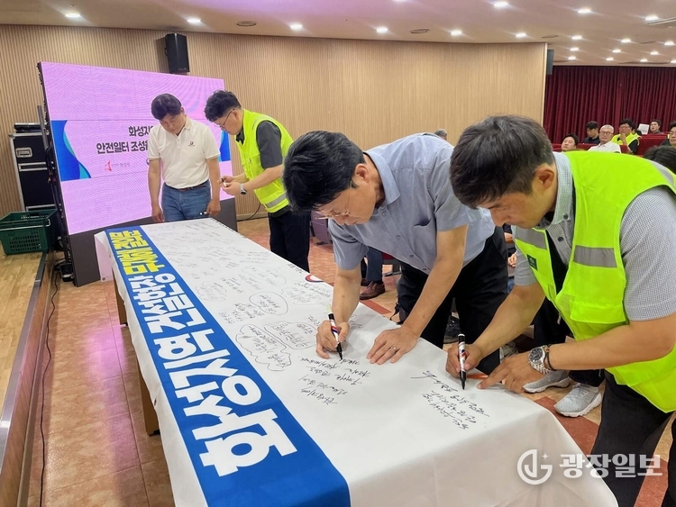 화성특례시 관내 공사현장 관계자 및 안전관리자들이 30일 무재해 결의대회에서 무재해 결의문 현수막에 안전기원 문구를 적고 있다