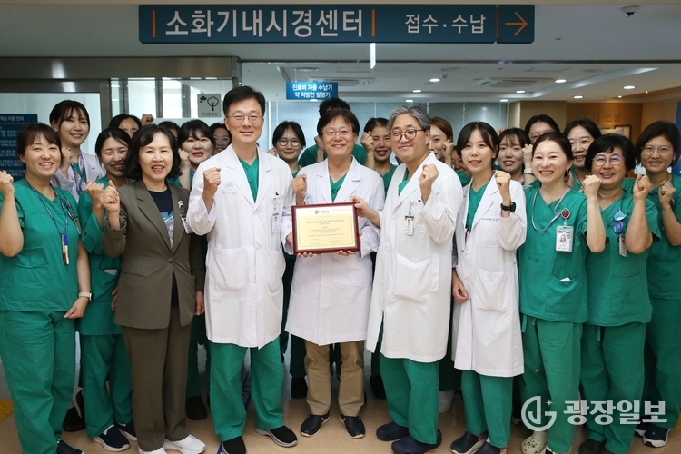 서울아산병원 소화기내시경센터 의료진이 세계내시경협회 최우수 내시경센터 인증패를 들고 기념촬영을 하고 있다.