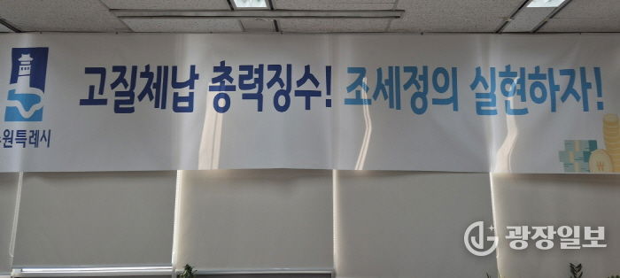‘고질체납 총력 징수! 조세정의 실현하자!’ 수원시 징수과 사무실에 걸려 있는 현수막.